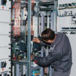 Electrician near the low-voltage cabinet. Uninterrupted power supply. Electricity.